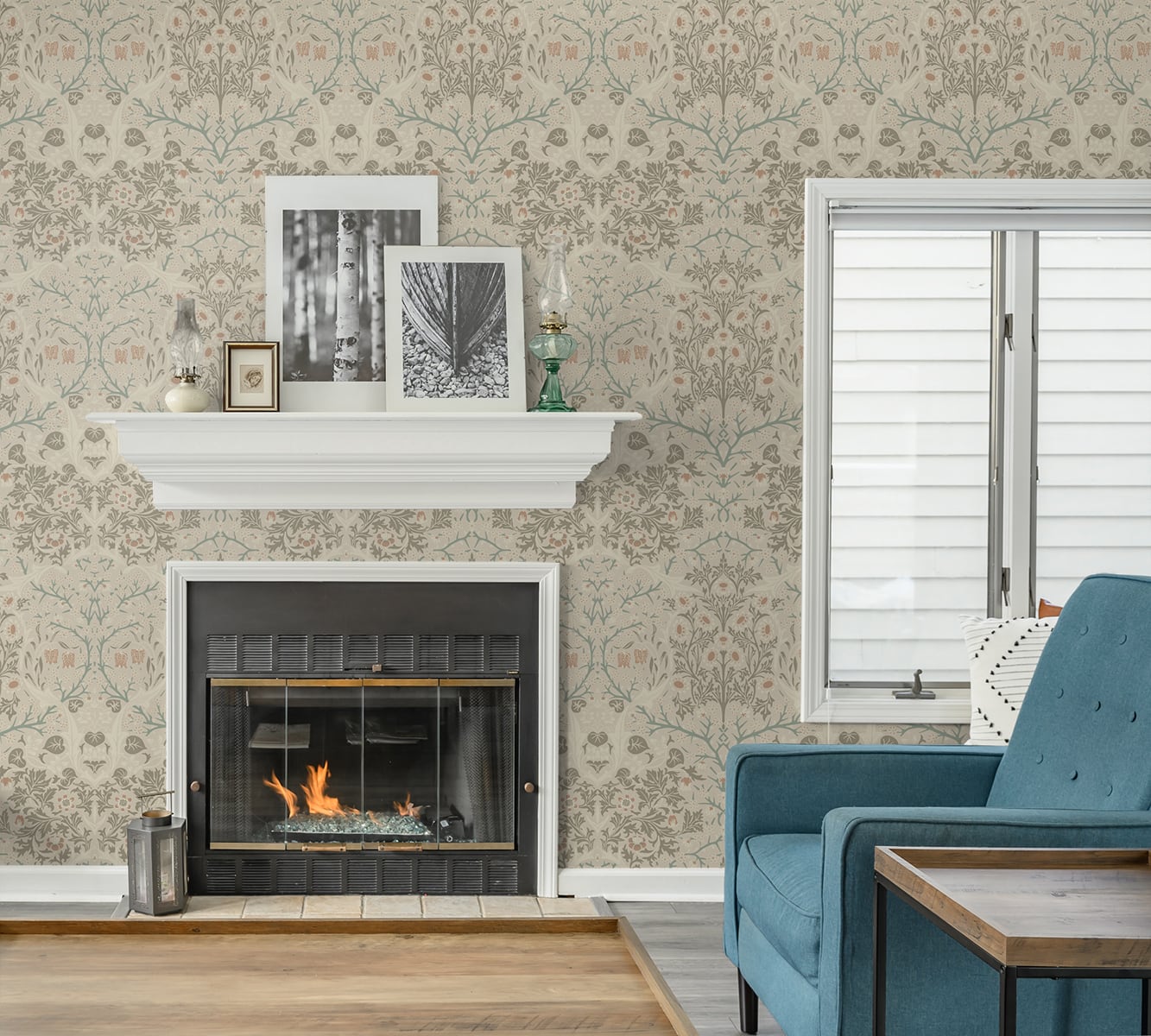 Living room with a fireplace, teal sofa, and decorative elements against a wall decorated with Beige Victorian Floral Peel & Stick Casa Mia Wallcovering.