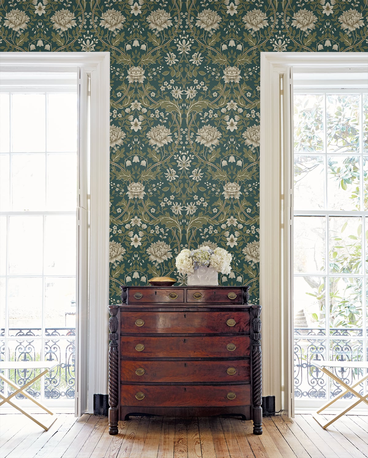 Floral wallpapered room with Teal Woodbine Trail Peel & Stick
Casa Mia Wallcovering and a wooden dresser and decorative elements.