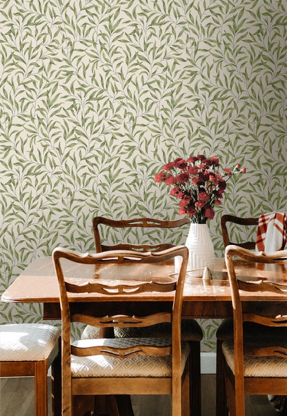 Dining room with wooden table and chairs against a wall decorated with Green Leafy Branches Peel & Stick Casa Mia Wallcovering.