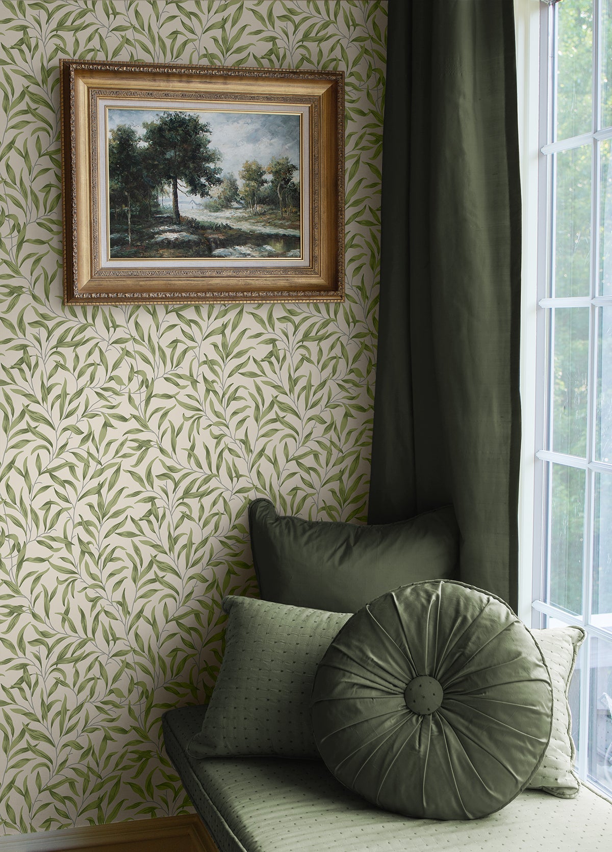 Green cushion on a bench against a wall with Green Leafy Branches Peel & Stick Casa Mia Wallcovering and a framed painting.