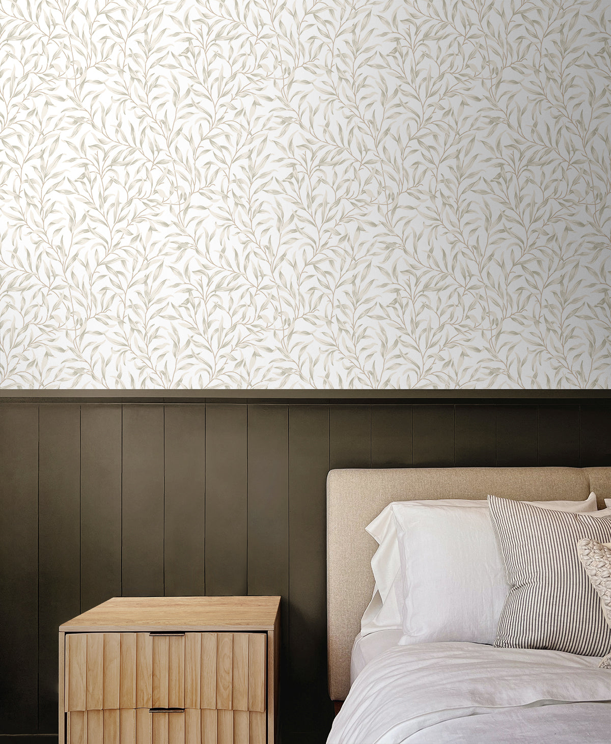 Bedroom wall decorated with Beige Leafy Branches Peel & Stick Casa Mia Wallcovering, wooden nightstand, and bed with striped pillows.
