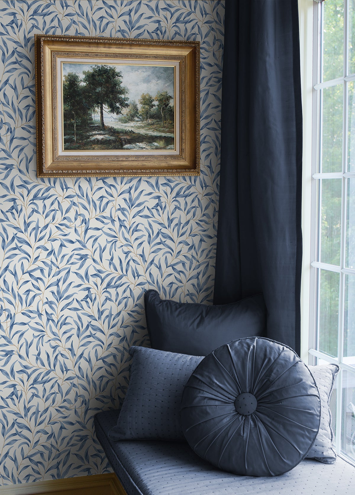Room interior wall decorated with Blue Leafy Branches Peel & Stick Casa Mia Wallcovering, framed painting, and blue cushions.
