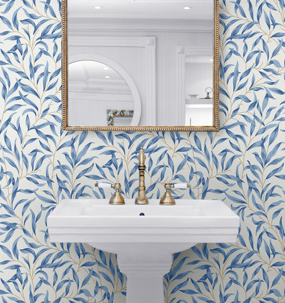 Bathroom wall decorated with Blue Leafy Branches Peel & Stick Casa Mia Wallcovering, white sink, and gold fixtures.