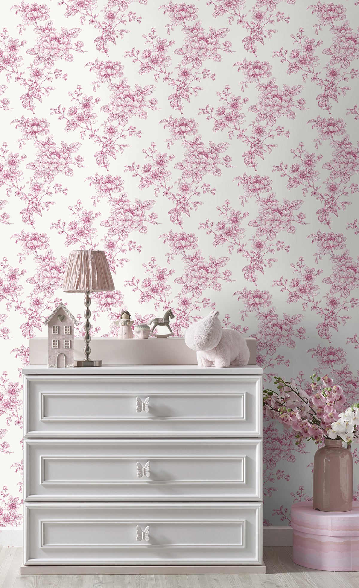 White dresser with decorative items against a wall decorated with Pink Cherished Rose Peel & Stick Casa Mia Wallcovering.
