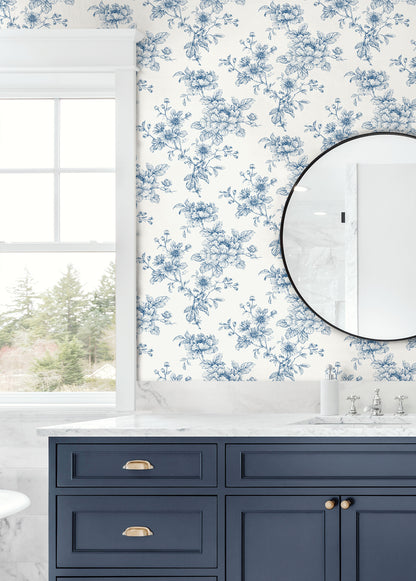 Bathroom wall decorated with Blue Cherished Rose Peel & Stick Casa Mia Wallcovering , navy vanity, and round mirror.
