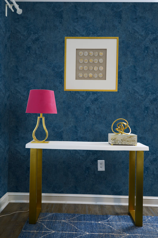 Classic white shelf with gold-colored supports, fuchsia lamp above, and a decorative ornament against a with Bleu Spatula Effect Wallpaper, 
