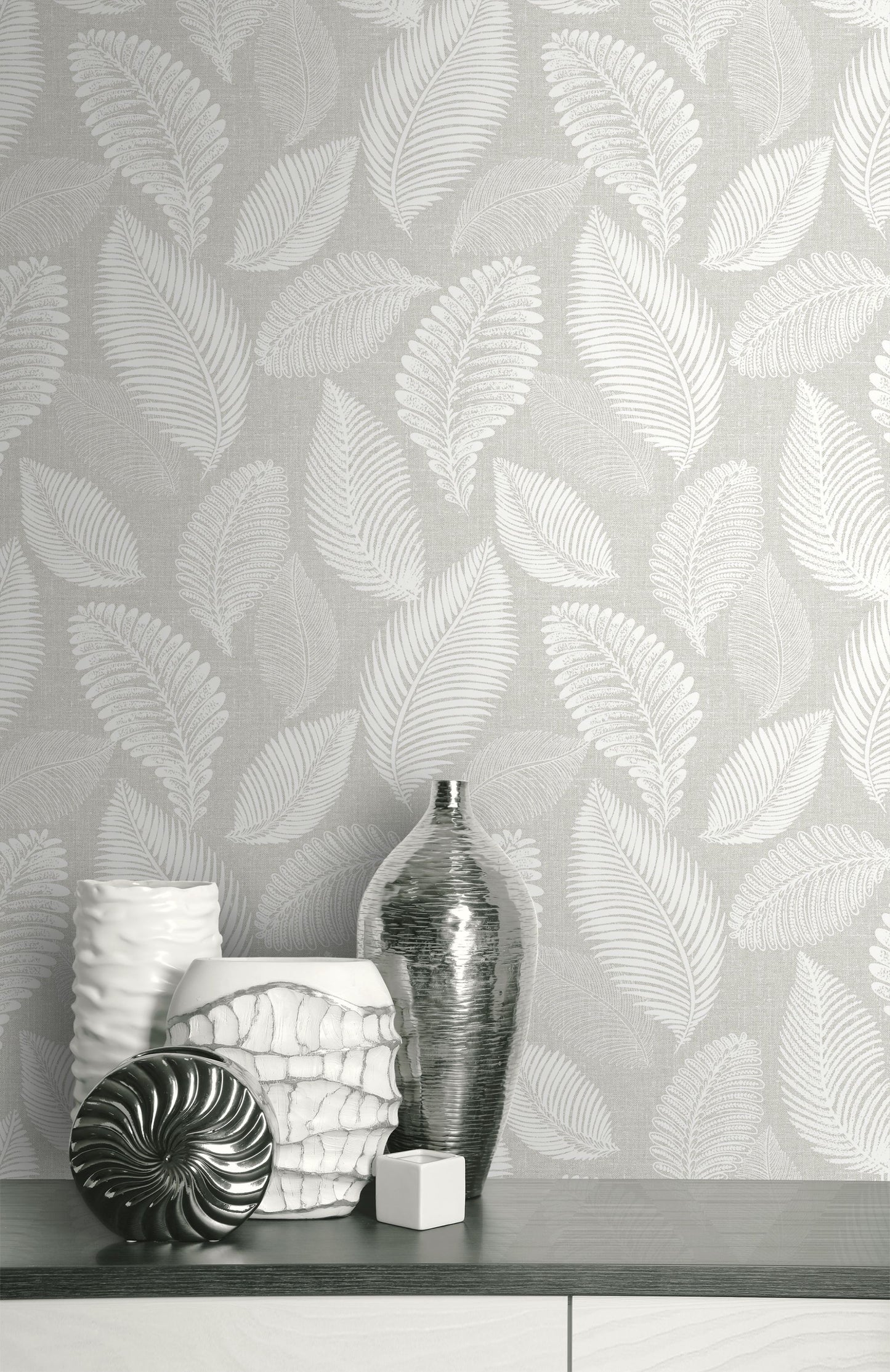 Wall decorated with Light Gray Scattered Leaves Wallpaper, featuring vases and decorative items on a shelf.