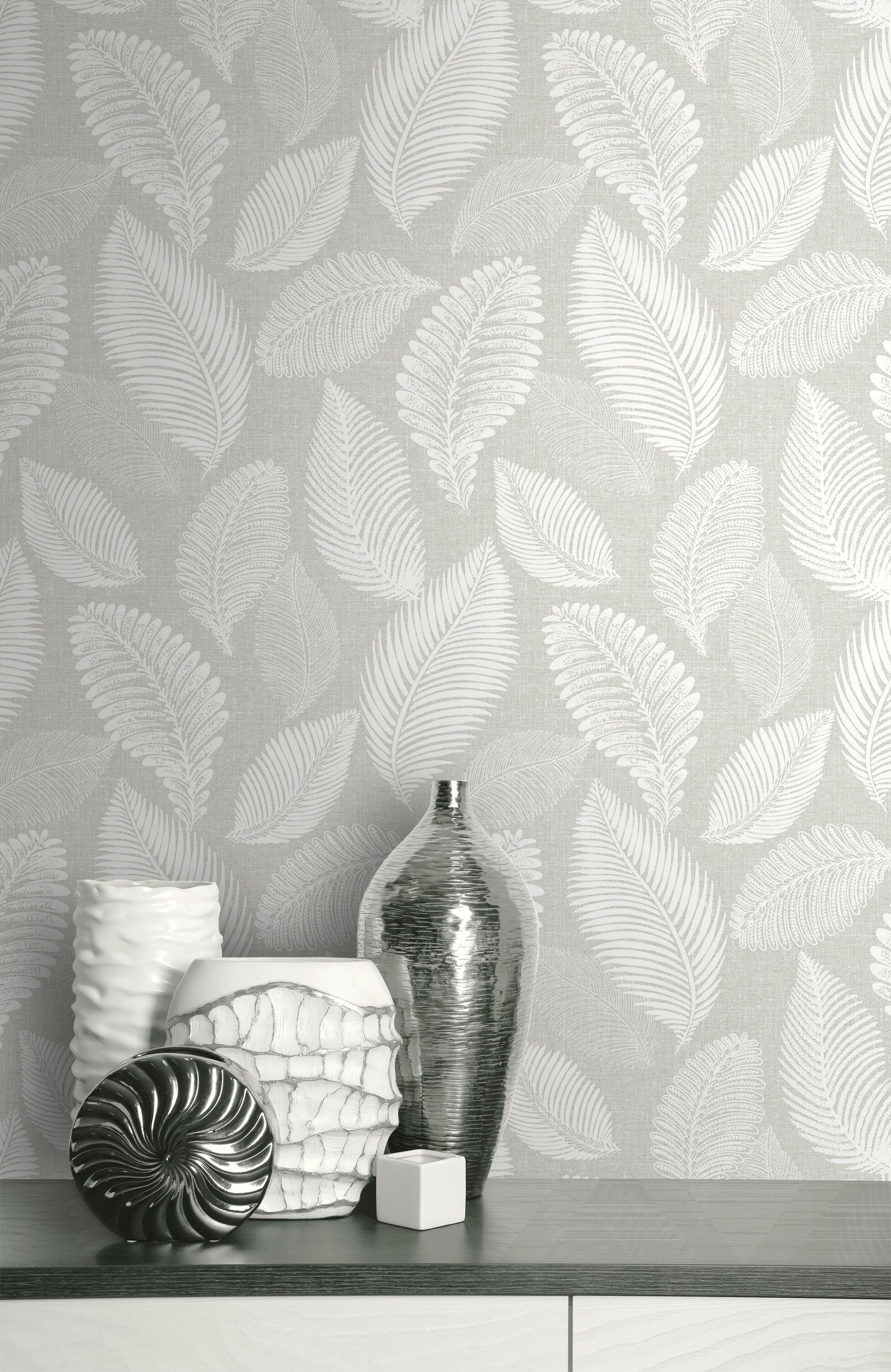 Wall decorated with Light Gray Scattered Leaves Wallpaper, featuring vases and decorative items on a shelf.