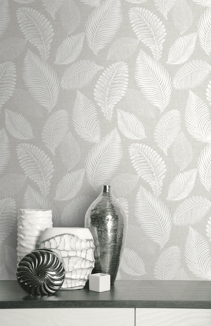 Wall decorated with Light Gray Scattered Leaves Wallpaper, featuring vases and decorative items on a shelf.