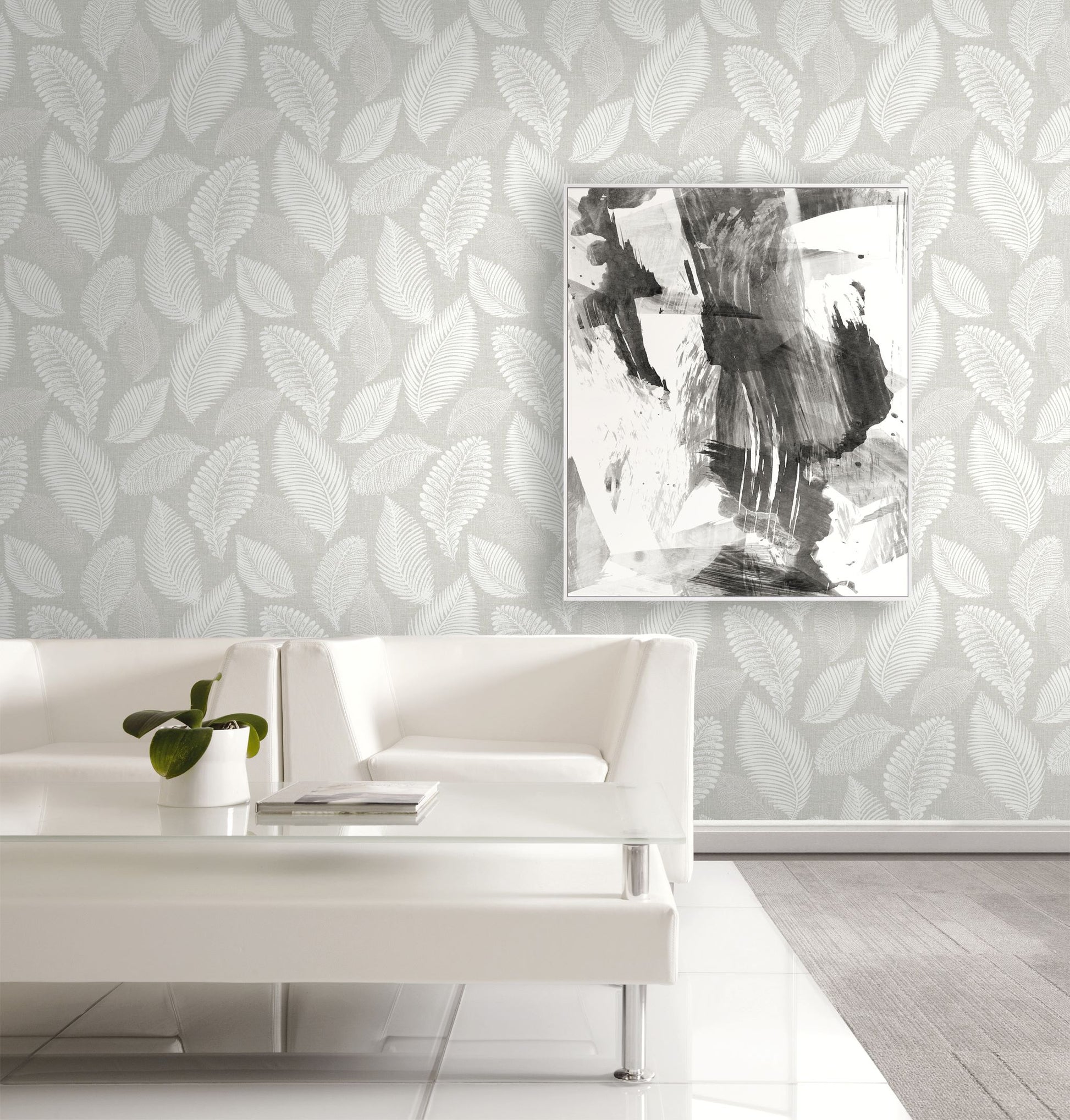 Modern living room with white sofa, abstract art, and wall decorated with Light Gray Scattered Leaves Wallpaper.
