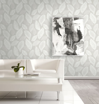 Modern living room with white sofa, abstract art, and wall decorated with Light Gray Scattered Leaves Wallpaper.
