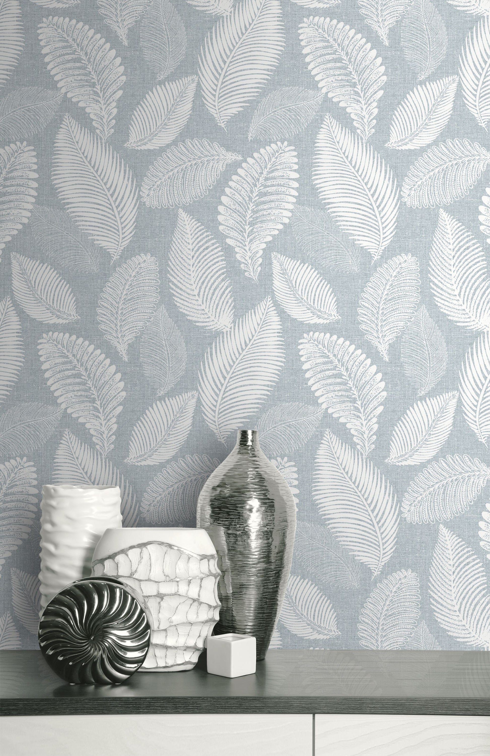 Wall decorated with Light Blue Scattered Leaves Wallpaper, vases on a shelf.