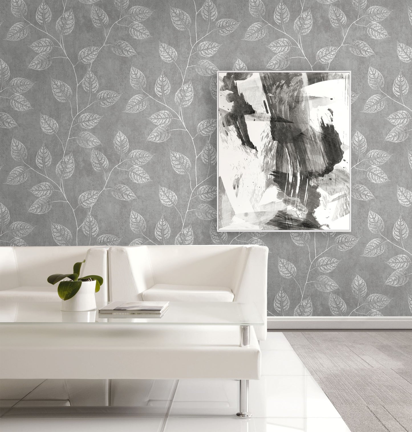 Living room with white sofa, abstract painting, and wall decorated with Mist Gray Branch Of Leaves Wallpaper.
