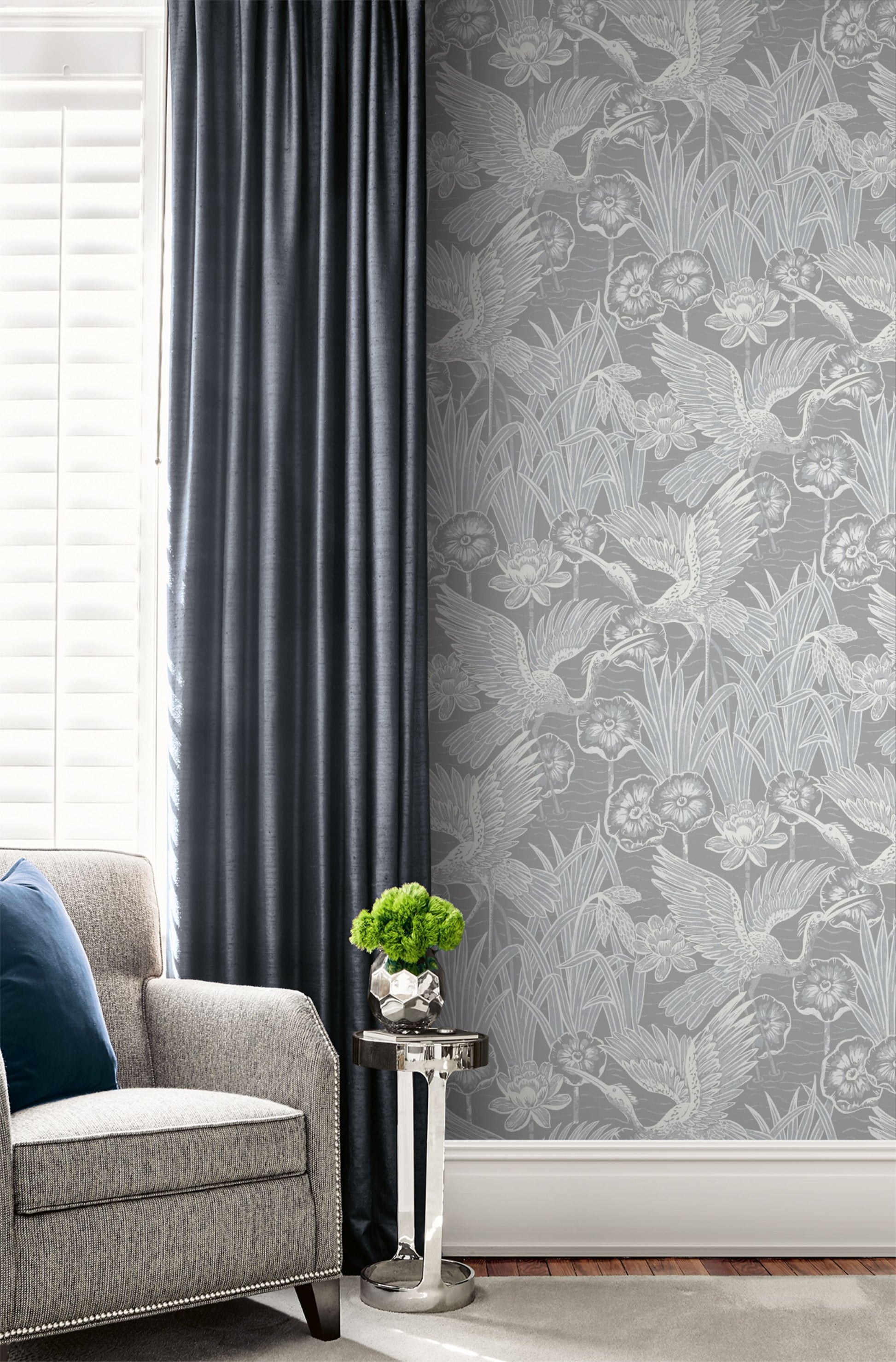 Living room with gray sofa, decorative plant, and a wall decorated with Gray Marsh Heron Wallpaper.
