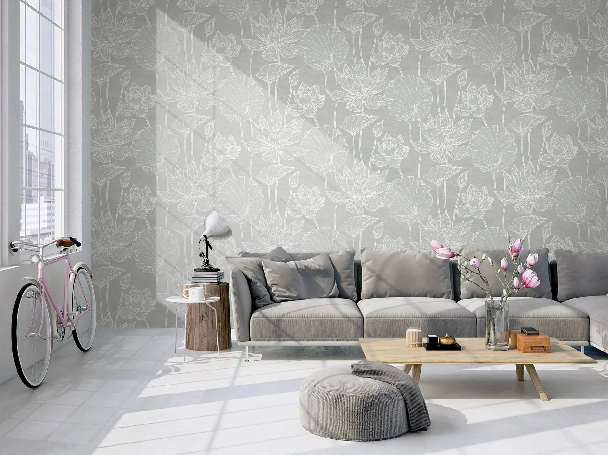 Modern living room with Lily Flower Wallpaper, gray sofa, coffee table, pouf, pink bicycle, and large windows.