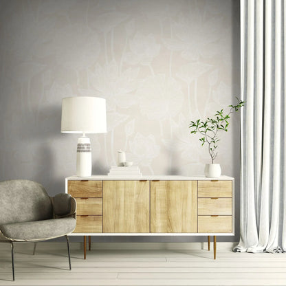 Modern living room with a wooden sideboard, gray chair, and Lily Flower Wallpaper behind a lamp and potted plant.