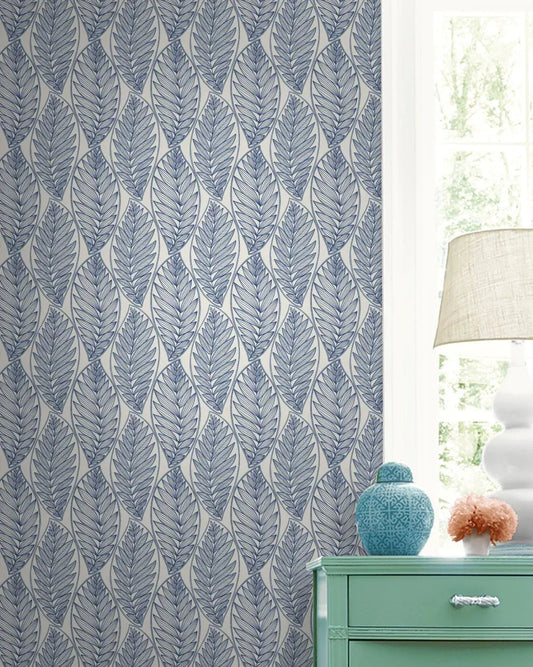 Kira Leaf Wallpaper, green dresser, lamp, and vase by a sunlit window with a white curtain.