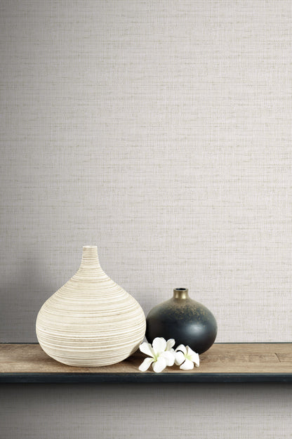 Two vases and a small white flower arrangement on a wooden surface with a wall decorated with Pebble Linen Fabric Commercial & Vinyl.
