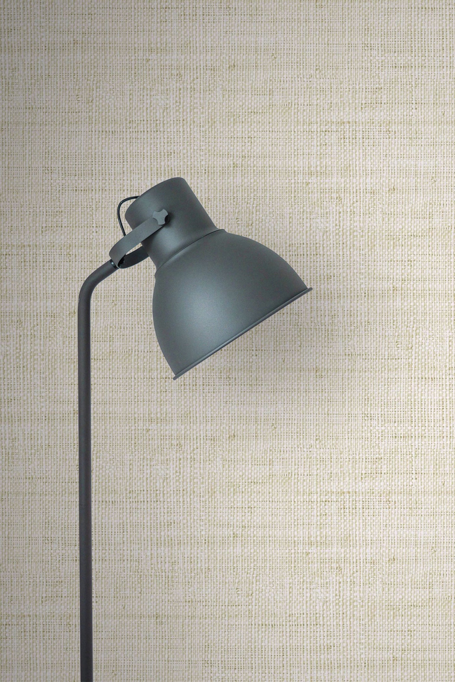 Dark gray wall lamp against a textured wall decorated with Ivory Linen Fabric Commercial & Vinyl.
