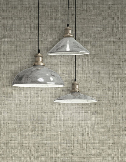 Three industrial-style pendant lights hanging against a wall decorated with Gray Linen Fabric Commercial & Vinyl.
