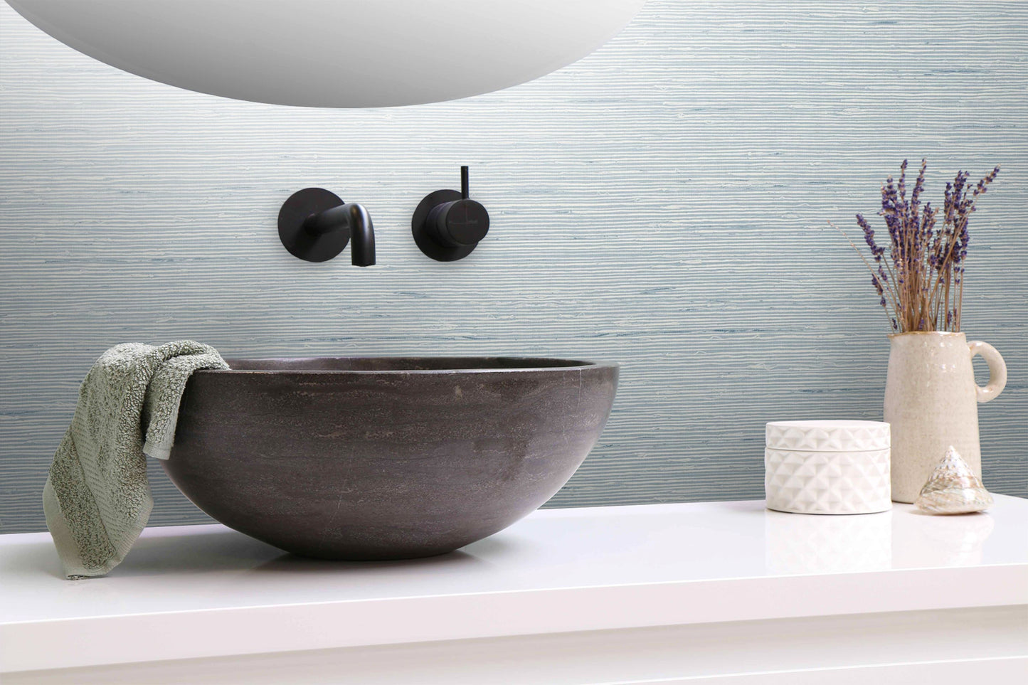 Bathroom sink with faucet, towel, and decorative items on a wall decorated with Light Blue Natural Weave Commercial & Vinyl.
