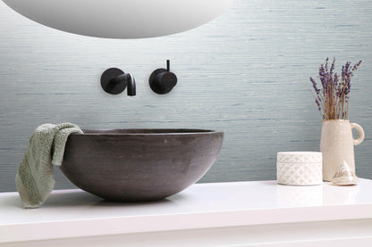 Bathroom sink with faucet, towel, and decorative items on a wall decorated with Light Blue Natural Weave Commercial & Vinyl.
