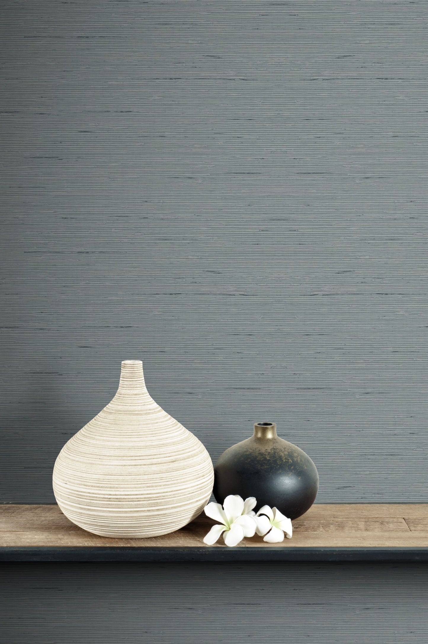 Two vases on a wooden surface with a wall decorated with Templeton Gray Natural Weave Commercial & Vinyl
 in the background.