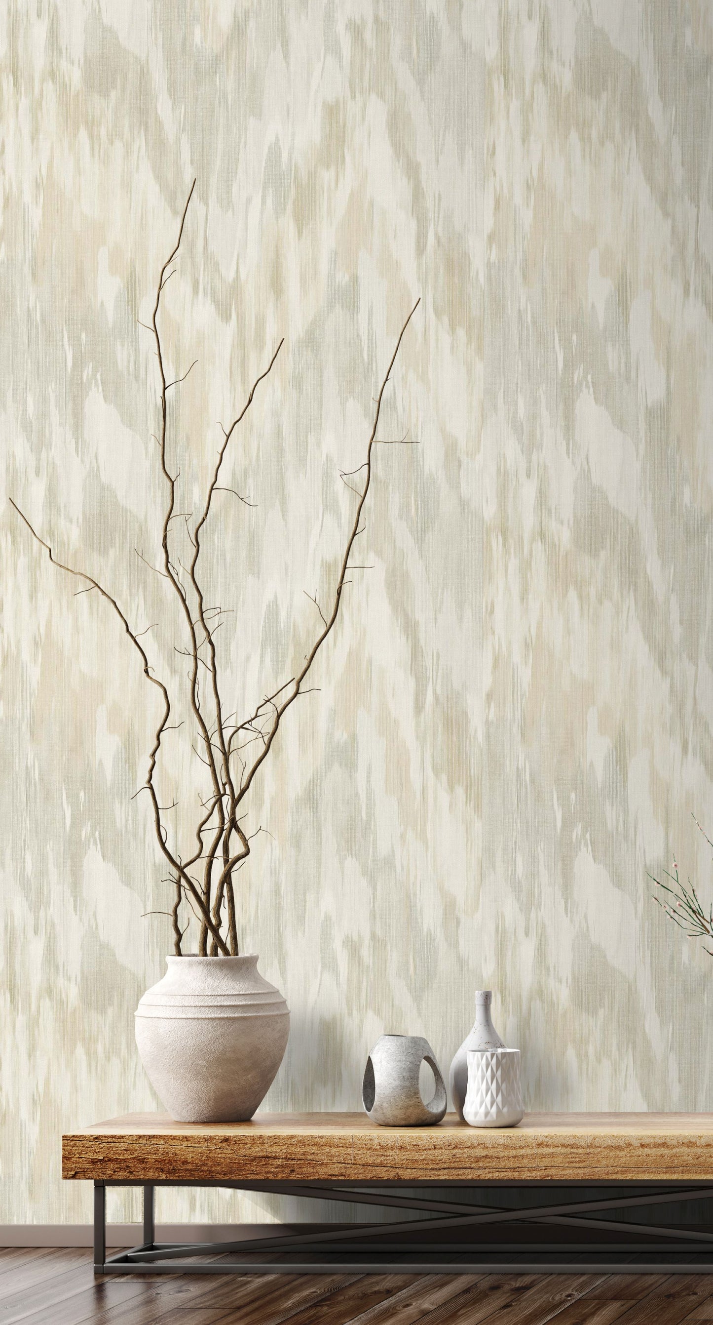 Vase with branches on a wooden table against a wall decorated with Beige & Green Watercolor Wave Wallpaper.
