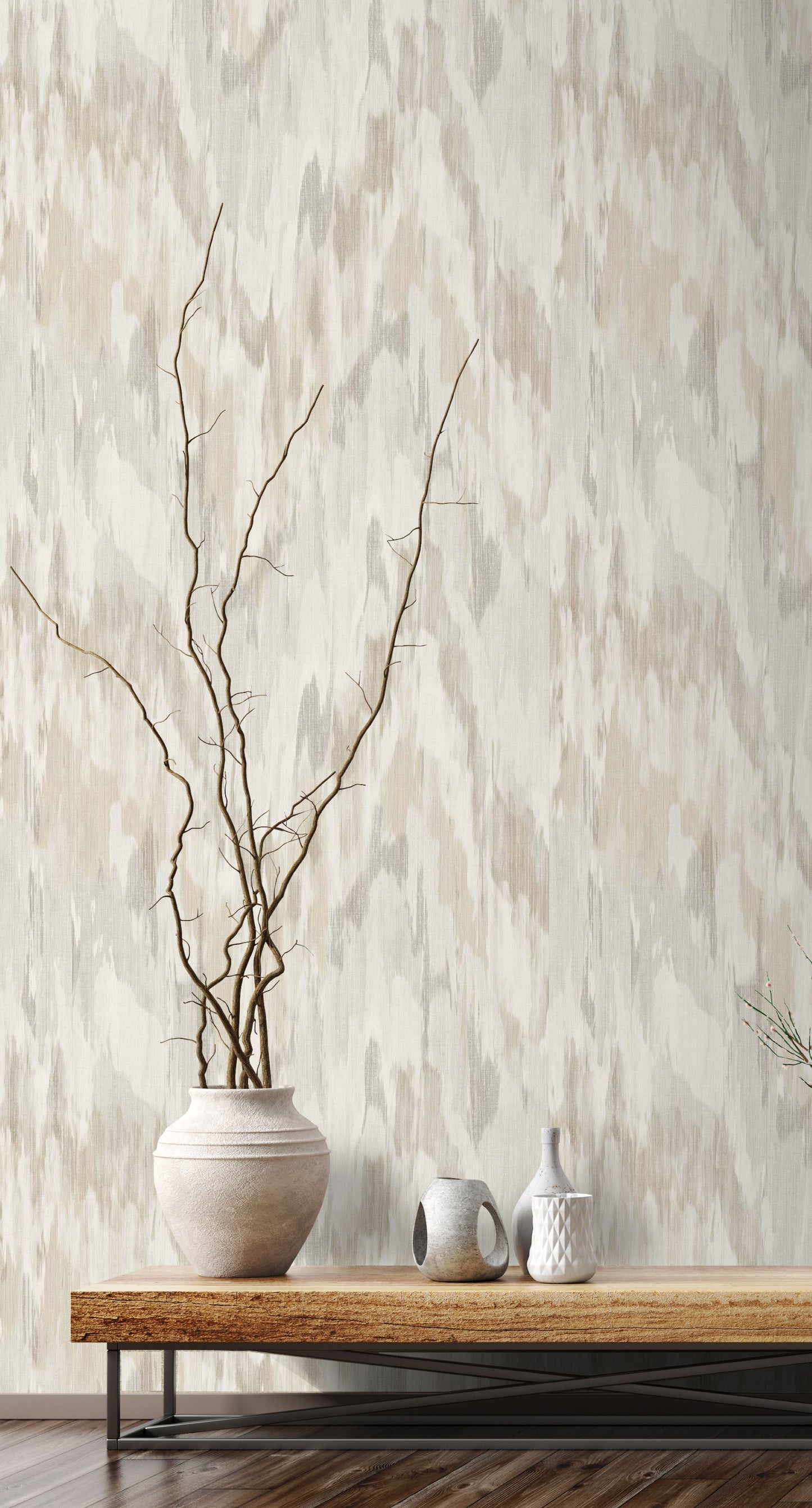 Vase with branches on a wooden table against a wall decorated with Beige & Gray Watercolor Wave Wallpaper.
