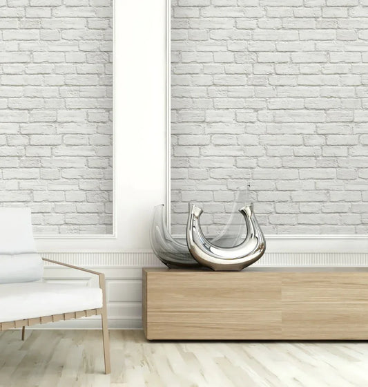 Modern minimalist room with Brick Peel Stick wallpaper, wooden bench, glass vases, and white chair on a light floor.