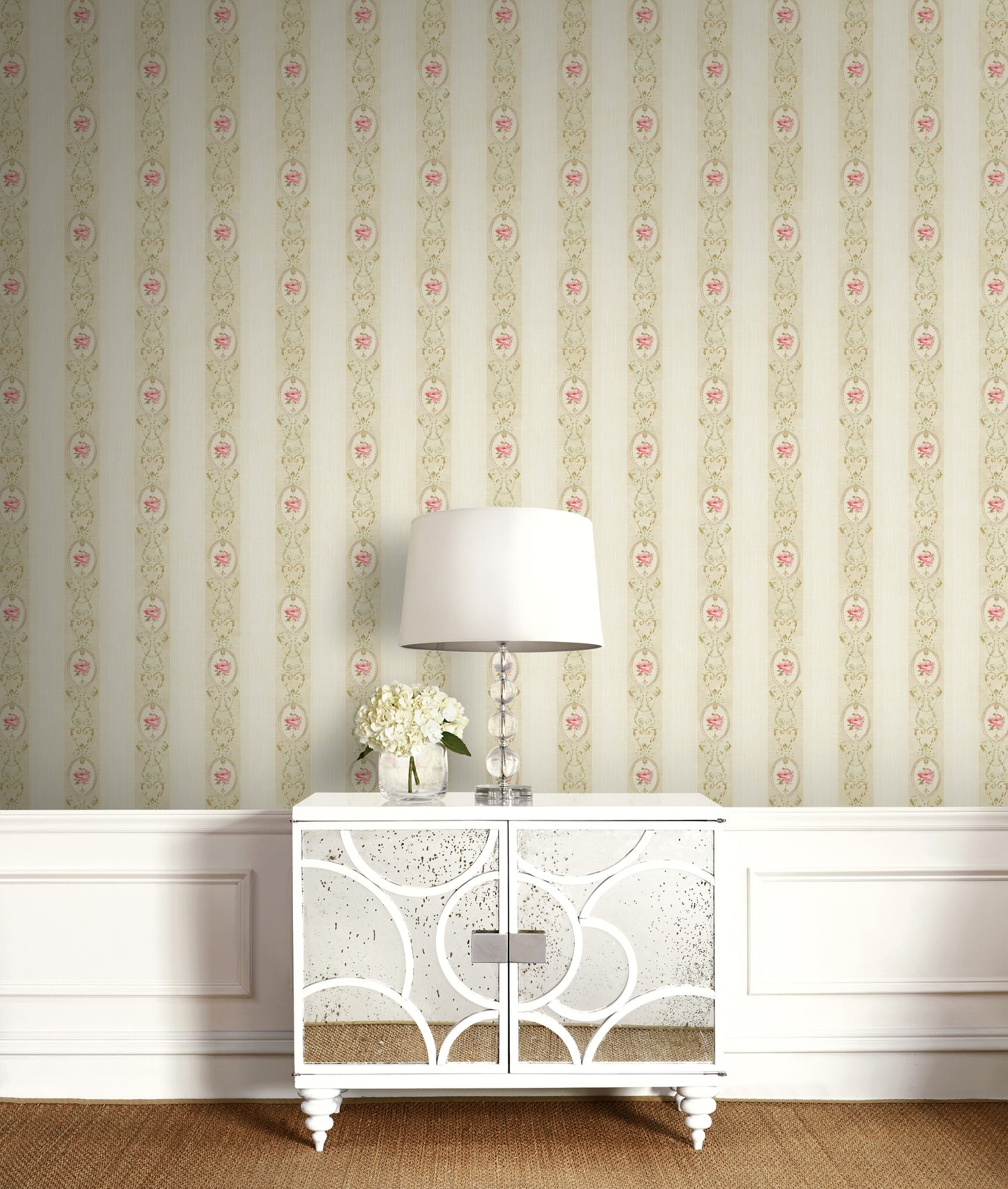 White cabinet with decorative patterns against a floral wallpapered wall.