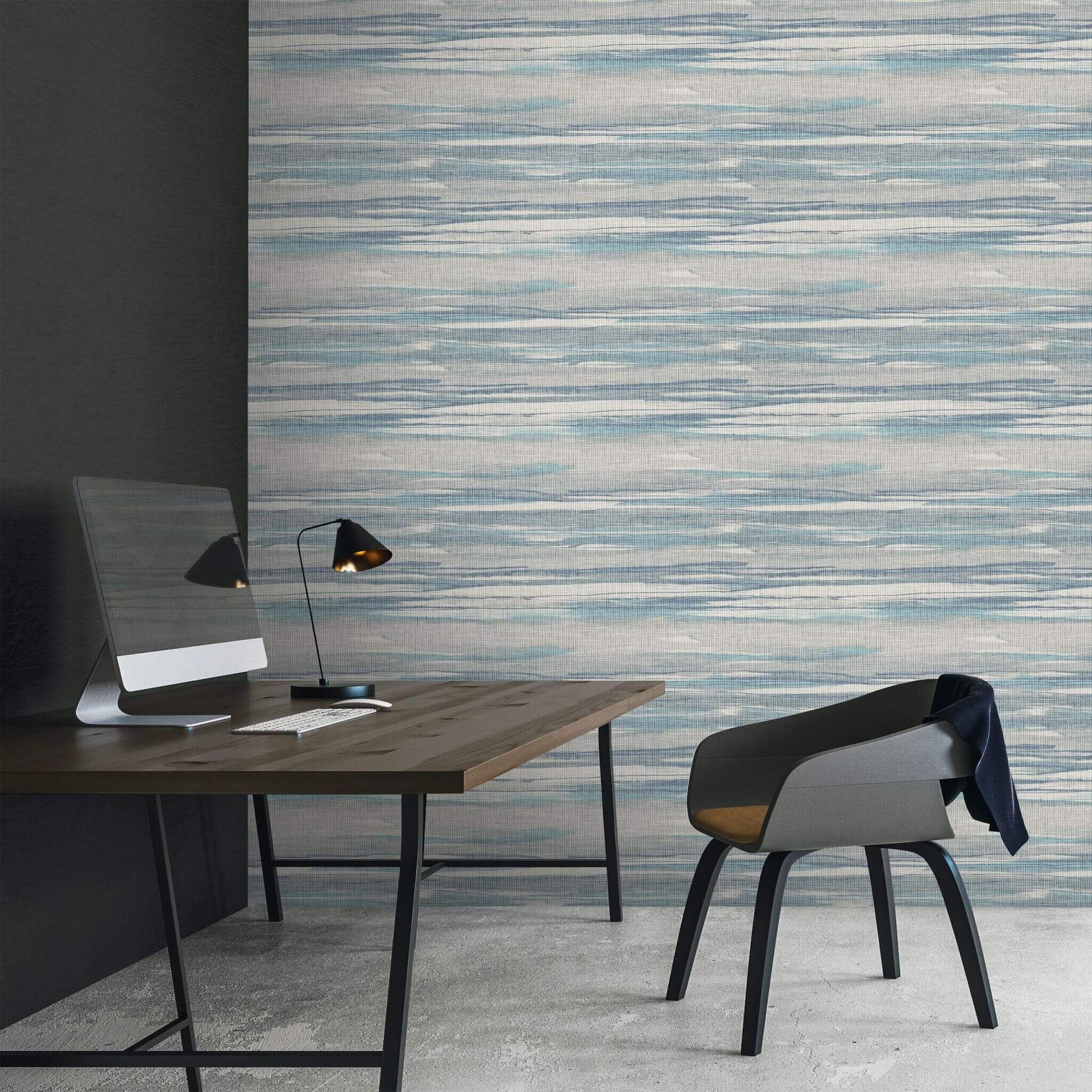 Modern office setup with a desk, chair, and lamp against a textured Bleu & Gray Grasscloth Waves Wallpaper.
